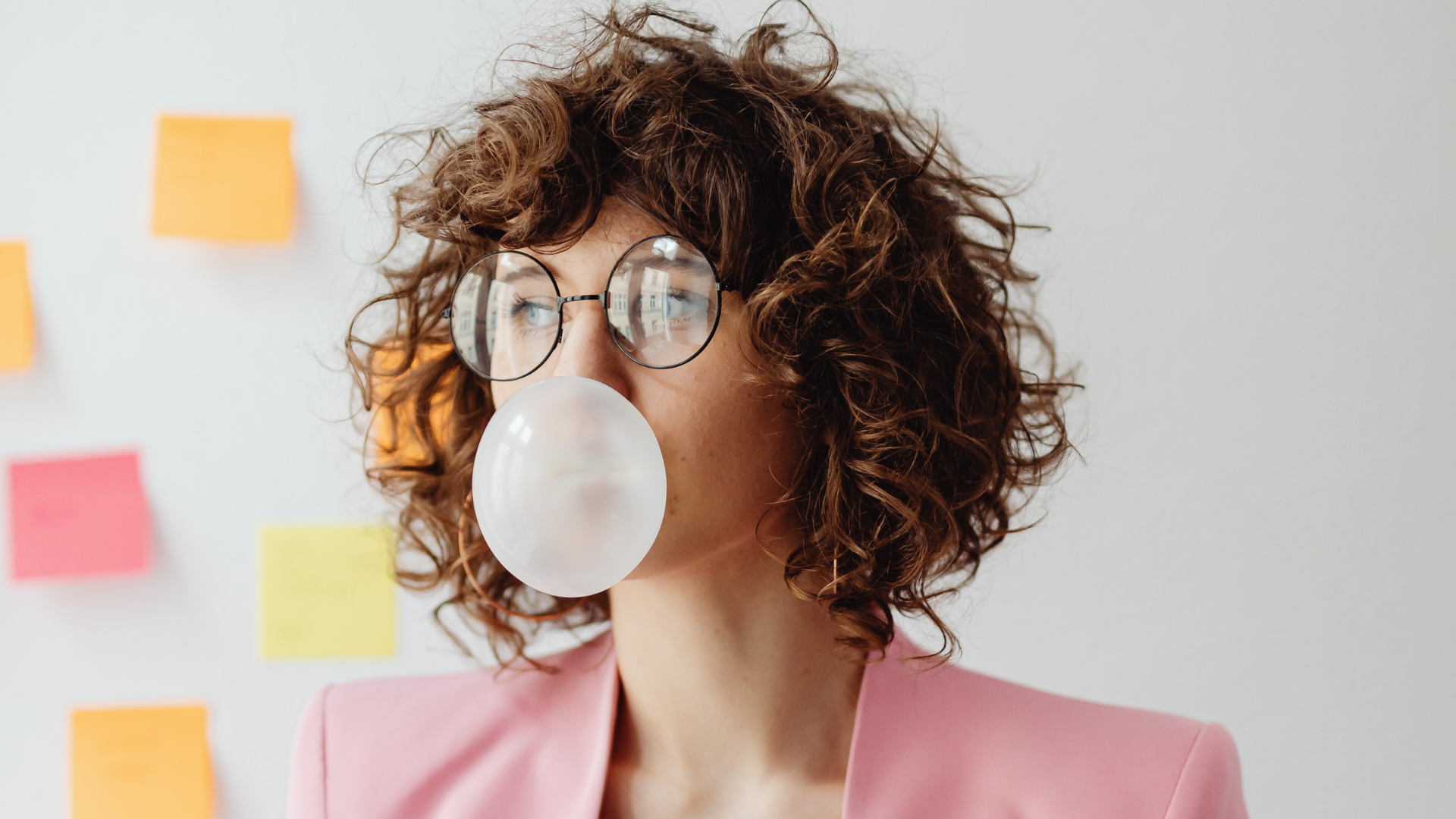 woman blowing bubble w/ chewing gum